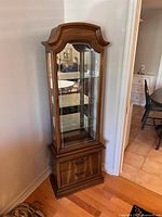 Full view of the vintage Hespler curio cabinet showing the wooden frame, glass door, interior with shelves, and bottom storage drawer.
