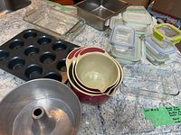 Overview of all bakeware including muffin pan, glass dishes, mixing bowls, metal tube pan, and glass storage containers with lids.