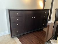 Front angle view of the buffet showing drawers and cabinet doors with espresso finish and square metal handles.