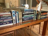 Photo of assorted books on a wooden table featuring travel, reference, dictionaries, and psychology books.