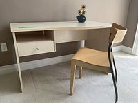 Desk and chair setup against wall showing drawer and chair details