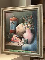 Full view of the framed oil painting showing still life with flowers, pottery, and basket.