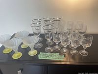 View of full assortment of glassware on black surface showing all items.