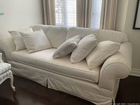Full view of ivory raw silk sofa with five cushions