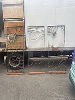 Three wrought iron panels propped against truck showing overall lot