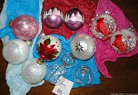 Photo showing 12 hand painted Christmas ornaments with various festive designs including cardinals, poinsettia, trees, stars, and glitter accents.