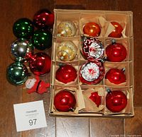 Photo of 18 vintage mercury glass Christmas ornaments including different colors, shapes, and a small flocked Santa figure. Box with paper dividers holding the ornaments visible.