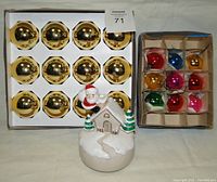 Box of 12 large gold mercury glass ball ornaments and box of 9 small assorted colored ball ornaments, with 1981 Otagiri ceramic Santa musical figurine in front.