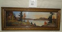 Full view of the antique 1920s oil pastel landscape painting in its original wooden frame, showing scenic lake and trees.