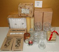 Full lot showing packaging and grouping of candles and holders, including IKEA boxed candles and holders and beeswax candles.