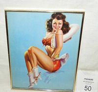Framed vintage pin-up girl lithograph print showing a smiling cowgirl in red shorts and boots on a blue background.
