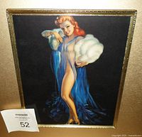 Framed vintage pin up girl print featuring a red-haired woman in blue and white stole, standing against a dark background.