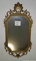 Front view of the ornate gold framed mirror showing the decorative design and overall shape.