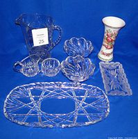 Full lot of vintage crystal cut glass items and porcelain vase arranged on blue background