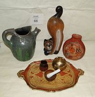 Photo showing seven vintage items including ceramic jug, carved wooden cat, pottery vase, decorative tray, wooden container, brass candle holder, and wooden mortar and pestle