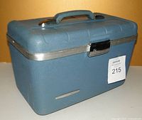 Front and top view of blue hard shell plastic vintage case with handle and clasp