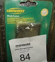 Front view of Yardworks 20-inch lawnmower blade in green and yellow packaging showing brand and model fit info.