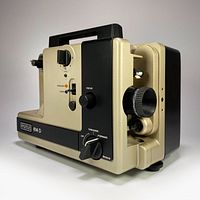 Angled front view showing control panel, film threading lever, focus knob, and speed selector.