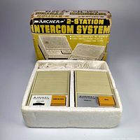 Original packaging showing the 2-station intercom system housed in white Styrofoam, box showing 'Archer 2-Station Intercom System' text.