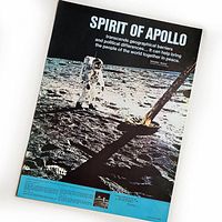 Full view of the Apollo 11 poster showing astronaut Buzz Aldrin on the Moon with text and lunar module footpad visible.