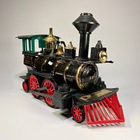 Front and three-quarter view of the vintage Jim Beam Grant 1872 locomotive train decanter showing black body, gold details, green cabin, and red wheels and front cowcatcher.