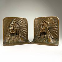 Pair of bronze bookends side by side showing front detailed chief reliefs.