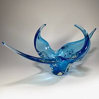Blue and clear freeform art glass bowl with 4 pointed arms curving up and out, thick glass base, glossy finish.