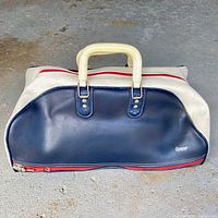 Front view of the vintage Cooper gym bag showing navy blue main panel, white handles, and red zipper.