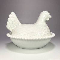Front view of the vintage white milk glass hen on a nest candy dish, showing detailed hen lid and nest base with bead rim.