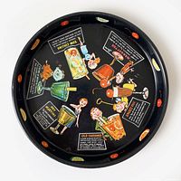 Top view of the round black metal bar tray with colorful cocktail recipes and cartoon illustrations by Jack Carpenter.