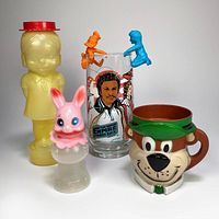 Full lot of six vintage toy items including Yogi Bear mug, Star Wars glass, McDonald's figures, rabbit container, and girl coin bank.