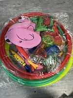 Top view of packaged 45pcs pool toys including colorful swim rings, foam flamingo floaties, and assorted sinkable dive toys in bright colors.