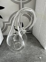 Clear glass Klein bottle photographed from an angle showing the continuous loop and hollow interior.