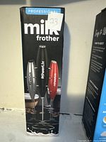 Front panel of the Powerlix milk frother box showing the product image in black, silver, and red color options and brand name