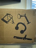 Box showing black line art illustrations of the workout accessories included inside: Double D handle, Tricep Rope, Straight Bar, V-shaped Bar.
