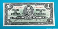 Front view of 1937 Canadian one dollar banknote displaying full face of King George VI portrait, serial number 1046065, and bilingual text.