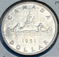 Close-up of the reverse side of 1951 Canadian Silver Dollar coin showing the canoe and figures with birds flying.