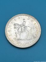 Obverse showing RCMP Mounted Police officer on horseback, text 'CANADA DOLLAR' and dates '1873-1973'.