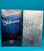 Front view of two sealed Royal Canadian Mint 25 Cent Coin sets from 2000, Celebration and Pride themes, showing packaging design and text.
