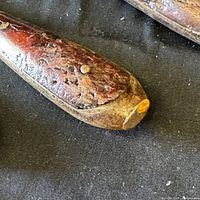 Close-up of wood handle showing wear, texture, and nail securing shaft