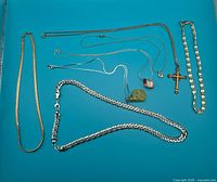 Full view of all chains and pendants arranged flat on blue background