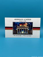 Front view of card packaging labeled 'GERMANY UNITED October 3, 1990' featuring Brandenburg Gate and map of Germany with text in German and English.