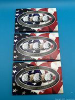 Three unopened sets of Gold Edition 5 state quarters from the years 1999, 2000, and 2001 with American flag packaging.