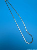 Full view of the gold filled chain necklace laid out showing its length and clasp.