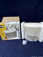 Hunter HEPAtech 55 air purifier in original packaging and styrofoam, including mounting hardware bag and outer box with family image.