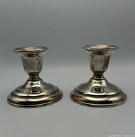 Pair of vintage Birks sterling silver candlesticks shown from front on a white background, minor tarnishing visible.