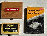 Photo showing Craftsman Forster bit set wooden box, Craftex 4-piece plug cutter set metal box, and boxed gluing clamp