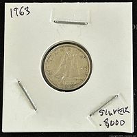 Reverse side of 1963 Canadian silver 10 cent coin showing Bluenose schooner design, in white cardboard holder with handwritten notes.