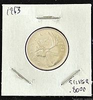 Reverse side of the 1963 Canadian 25 cents silver coin featuring a caribou and denomination 25 cents.
