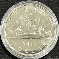 Reverse of the 1976 Canadian 1 Dollar coin showing canoe scene, date 1976 and inscriptions with a proof-like finish.
